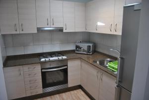 a small kitchen with white cabinets and a sink at Ático Tanausú in Arrecife
