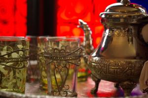 a table topped with glasses and a tea kettle at Riad Ibn Battouta & Spa in Fez