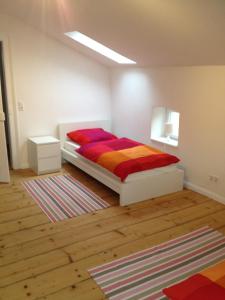 Schlafzimmer mit einem Bett mit farbenfroher Bettwäsche in der Unterkunft Apartment Villa Elisa in Bad Kreuznach