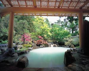 a large pool of water in a garden with trees at Unzen Fukudaya in Unzen