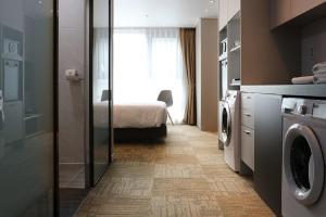 a bathroom with a washer and dryer in a room at Royal Square Hotel Seoul in Seoul