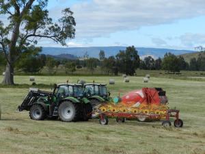 a tractor and a tractor trailer in a field at Glenfield Cottage in Yarck