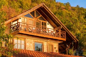 a house with a balcony on top of it at Robinson Sunset Guest House in Ohrid