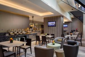 ein Restaurant mit Tischen und Stühlen und eine Bar in der Unterkunft Carlton Hotel Singapore in Singapur