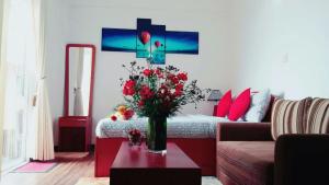 um quarto com uma cama com um vaso de flores sobre uma mesa em Spencer Holiday Apartments/Seagull complex em Nuwara Eliya