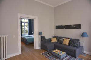 a living room with a couch and a bed at City-Apartment Reger Privatparkplatz in Krefeld