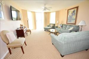 a living room with a blue couch and chairs at 207 North Tower Condo in Myrtle Beach