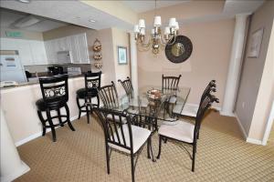 a dining room with a glass table and chairs at 207 North Tower Condo in Myrtle Beach