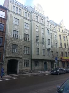 un gran edificio de piedra en una calle de la ciudad en Sunlit Loft Apartment Riga, en Riga