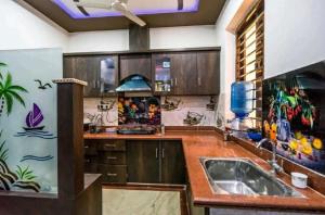 a kitchen with wooden cabinets and a sink at Friends Home Stay - Agra in Agra