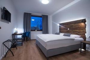 ein Hotelzimmer mit einem Bett, einem Schreibtisch und einem Fenster in der Unterkunft Hotel Wiesengrund Business & Boutique in Dinklage