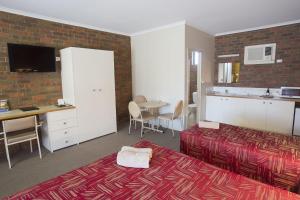 a bedroom with a bed and a desk and a table at Horsham Country City Motor Inn in Horsham
