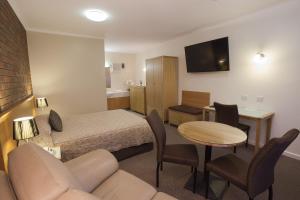 a hotel room with a bed and a table and chairs at Horsham Country City Motor Inn in Horsham