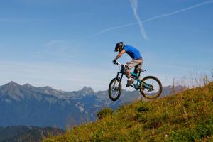 レ・キャローズ・ダラッシュにあるBelleVue centre, wifi, mountain viewの丘の上で自転車に乗って芸をする男性