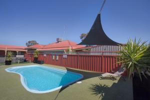 een zwembad voor een rood gebouw bij Horsham Country City Motor Inn in Horsham