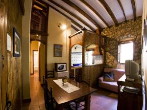 a dining room with a table and a living room at Molino Galán in Alborache