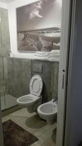 ein Bad mit WC, Waschbecken und Bild in der Unterkunft "Via Cavour 81" in Arezzo