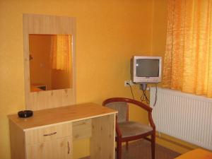 a room with a desk with a tv and a chair at Hotel Maritsa in Lyubimets