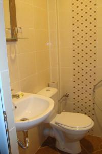 een badkamer met een wit toilet en een wastafel bij Hotel Maritsa in Lyubimets