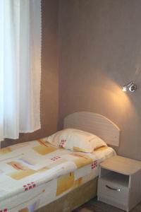 a small bedroom with a bed and a table at Hotel Maritsa in Lyubimets