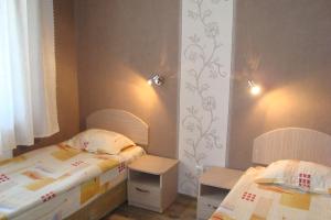 een slaapkamer met 2 bedden en 2 tafels bij Hotel Maritsa in Lyubimets