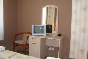 a room with a television on a dresser with a mirror at Hotel Maritsa in Lyubimets
