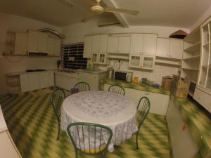 eine Küche mit einem Tisch mit Stühlen und einem Deckenventilator in der Unterkunft Casa Impiana in Kuantan