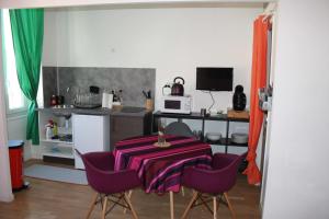 a kitchen with a table and some purple chairs at Casa Ammirati Apartments in Marseille