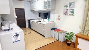 a small kitchen with white cabinets and a refrigerator at Shirahama Ocean Villa in Shirahama