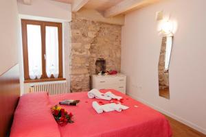 a bedroom with a red bed with flowers on it at Appartamento Malù Morgana in Tenno