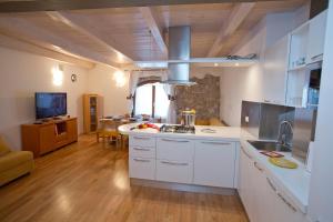 a kitchen with white cabinets and a large window at Appartamento Malù Morgana in Tenno