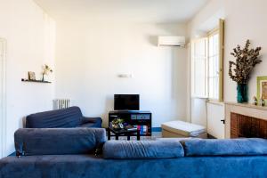 un soggiorno con divano blu e TV di PIAZZA MAZZINI APARTMENT a Roma
