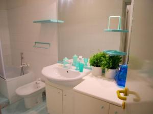 a white bathroom with a sink and a toilet at Appartamento Zipser II in Grado +138 photos