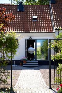 a person in the doorway of a house with a surfboard at Örum 119 in Löderup