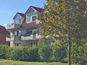 a large house with a tree in front of it at 2 Zimmer Appartement Poseidon in Boltenhagen