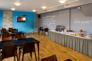 a dining room with tables and chairs and a chalkboard at Kolumbs Junior Suite in Liepāja