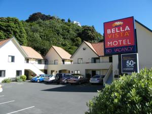 a hotel sign with cars parked in a parking lot at Bella Vista Motel Wellington in Wellington