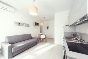 a living room with a couch and a kitchen at Luccainn in Lucca