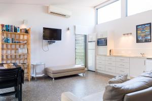 a living room with a couch and a tv at By the Beach B&B Self Contained Apartments in Sanctuary Point