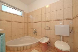 a bathroom with a tub and a toilet and a sink at Apartments Sanja in Vodice