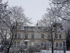 une grande maison avec des arbres devant elle dans l'établissement La Demeure d'Elodie, à Épernay