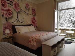 a bedroom with a bed with roses on the wall at La Demeure d'Elodie in Épernay