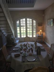 ein Esszimmer mit einem Tisch, Stühlen und einer Treppe in der Unterkunft Chambres d'hôtes les Marronniers in Bordeaux