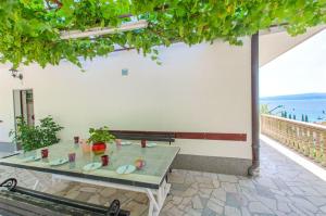 a table on a patio with a view of the ocean at Apartments Mladen in Duće