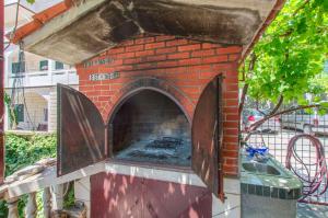 an outdoor brick oven with an open door at Apartments Mladen in Duće
