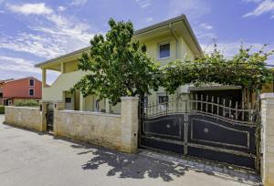 uma casa com um portão preto e uma cerca em Apartment Kraljevic em Umag