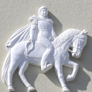 Eine weiße Statue einer Frau, die auf einem Pferd reitet. in der Unterkunft Apartments Weisser Reiter in Elfershausen