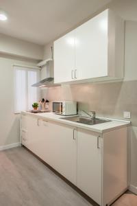 a white kitchen with white cabinets and a sink at Plaza Nueva Central Superior in Seville