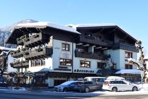 a large building with cars parked in front of it at Hotel Rösslwirt in Kirchberg in Tirol