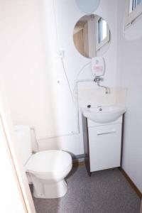 a white bathroom with a toilet and a sink at Hostel Metro in Warsaw
